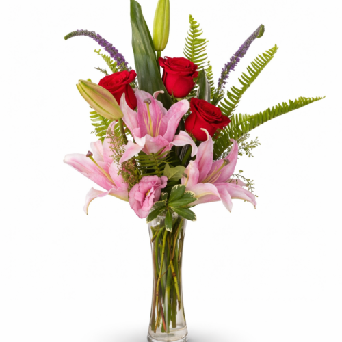 The Dots of Pink Lily & Rose Vase features pink lilies, red roses, ferns, and green foliage in a clear glass vase, artfully arranged by a Clayton NC Florist.