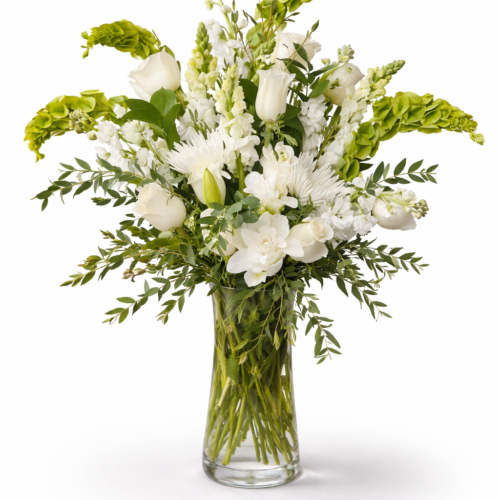 Simply Elegant Blooms features white roses, tulips, snapdragons, and fresh greenery in a clear glass vase—artfully arranged by Clayton Florist. Perfect for bringing elegant charm to any space with local Clayton NC flower delivery.