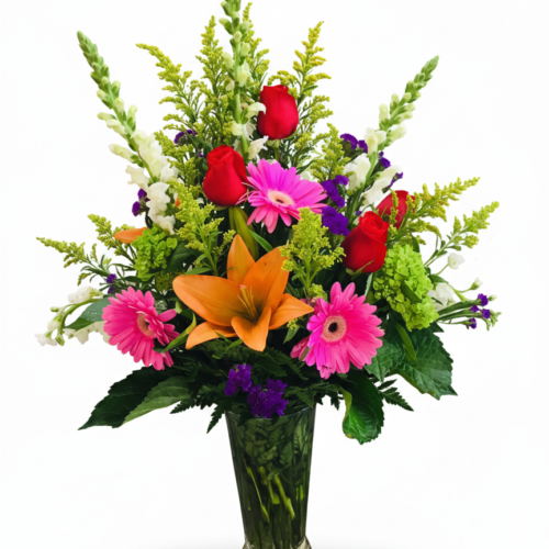 A Vibrant Gathering: A tall glass vase with orange lilies, pink gerbera daisies, and more—perfect for flower delivery in Clayton, NC by The Florist at Plantation.