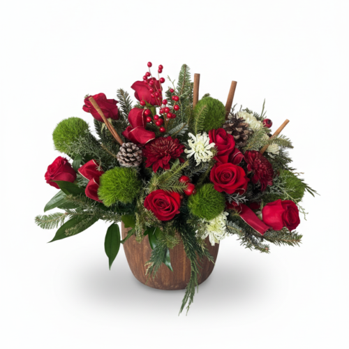 The Winter Woodland Glow is a festive arrangement in a wooden container with red roses, green moss balls, pinecones, white flowers, red berries, cinnamon sticks, and greenery—expertly crafted by your local Clayton florist.