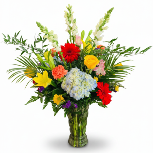 The Sweet Celebration Vase from your local Clayton florist features a colorful mix of red gerbera daisies, yellow lilies and roses, blue hydrangeas, snapdragons, orange carnations, pink blooms, and assorted greenery.