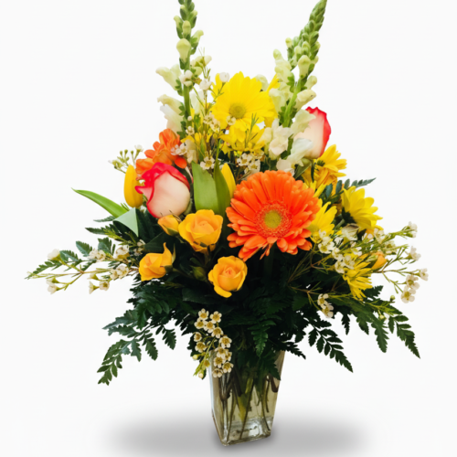 The Sunbeam Gathering Vase features a clear glass vase with vibrant orange gerbera daisies, yellow and white flowers, snapdragons, roses, and greenery—ideal for flower delivery in Clayton NC from The Florist at Plantation.