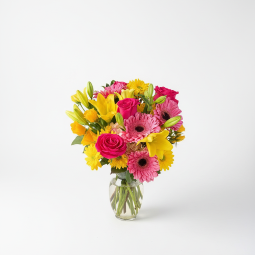 The Happy on Arrival arrangement features a clear glass vase from The Florist at Plantation, filled with pink gerbera daisies, yellow lilies, yellow daisies, and pink roses, set against a plain white background.