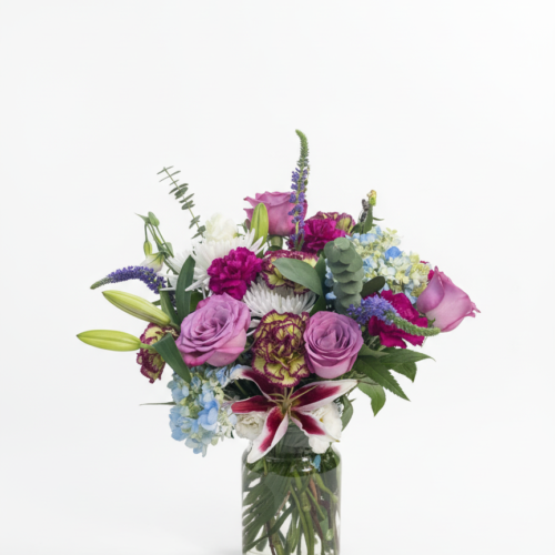 Blushing Meadows—a glass vase of roses, carnations, lilies, hydrangeas, and greenery—is artfully arranged by The Florist at Plantation. Ideal for Clayton NC Flower Delivery and showcased against a classic white background.